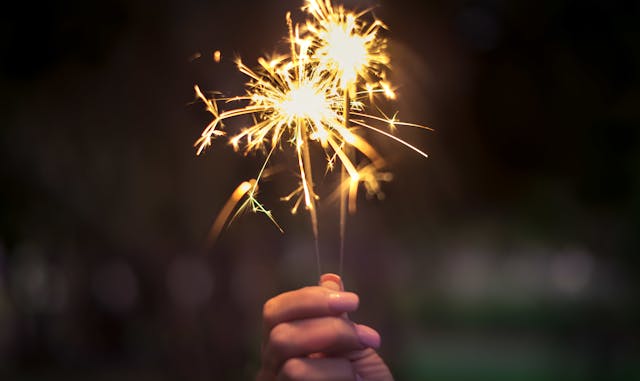 a woman holding firework stick